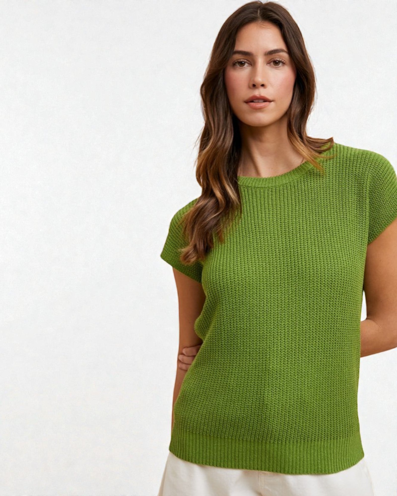 Woman wearing a green knitted top against a white background