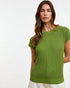 Woman wearing a green knitted top against a white background