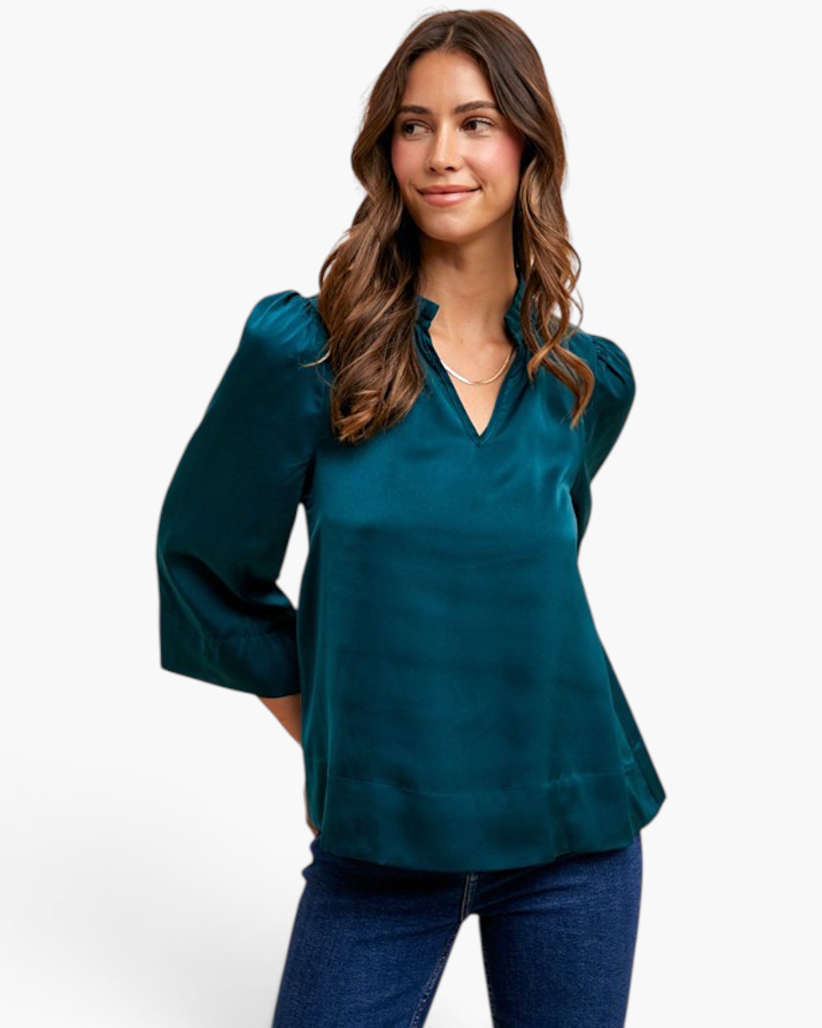 A woman modeling a teal satin blouse with three-quarter sleeves and a split V-neckline, paired with blue jeans against a plain white background.