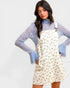 Woman wearing a floral dress over a blue sweater on a white background