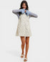 Woman wearing a floral dress and denim jacket on a white background