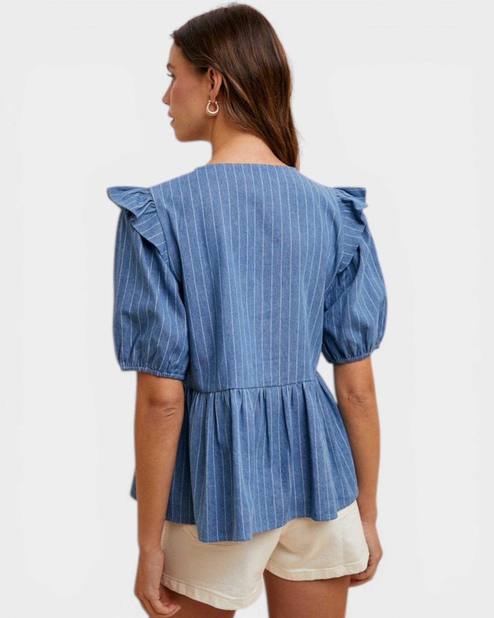 Woman wearing a blue striped blouse with puffed sleeves on a white background