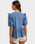 Woman wearing a blue striped blouse with puffed sleeves on a white background