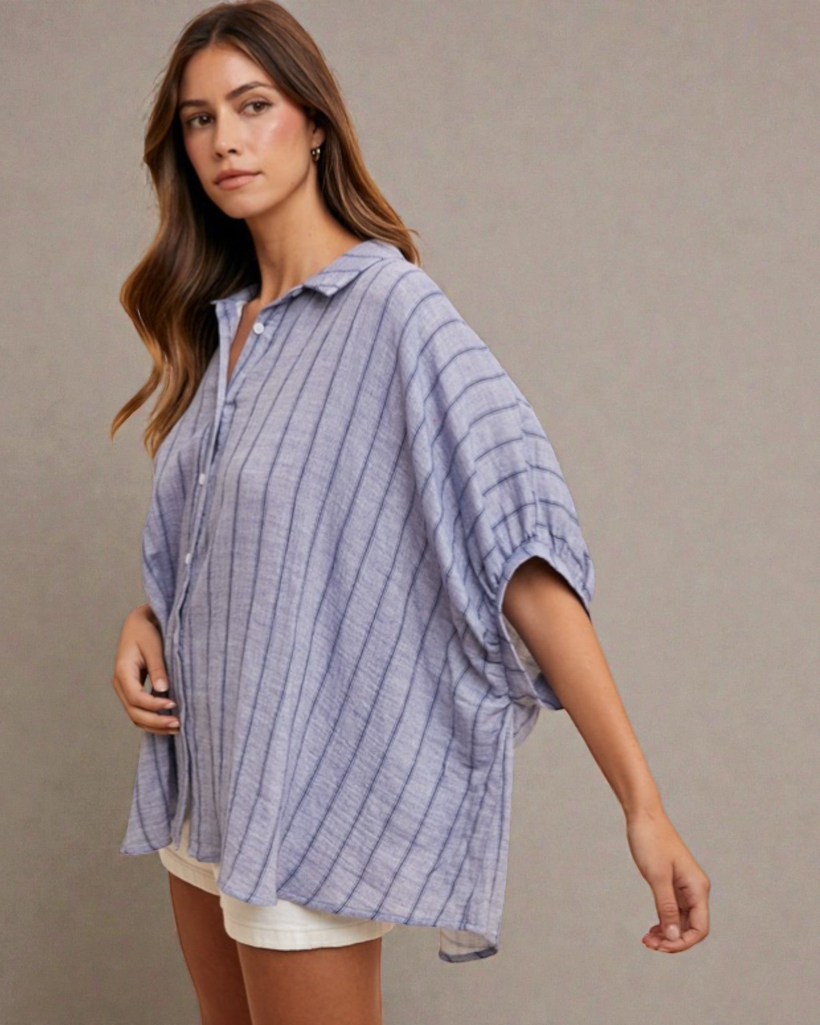 Woman wearing a blue striped shirt against a plain background