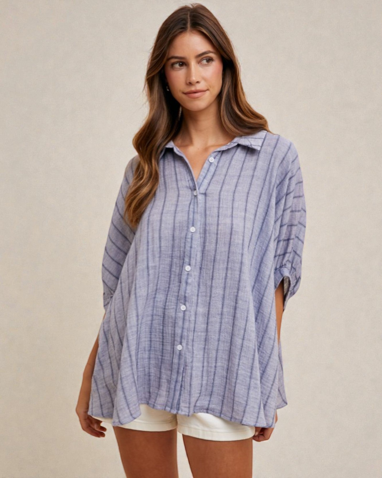 Woman wearing a blue striped shirt against a beige background