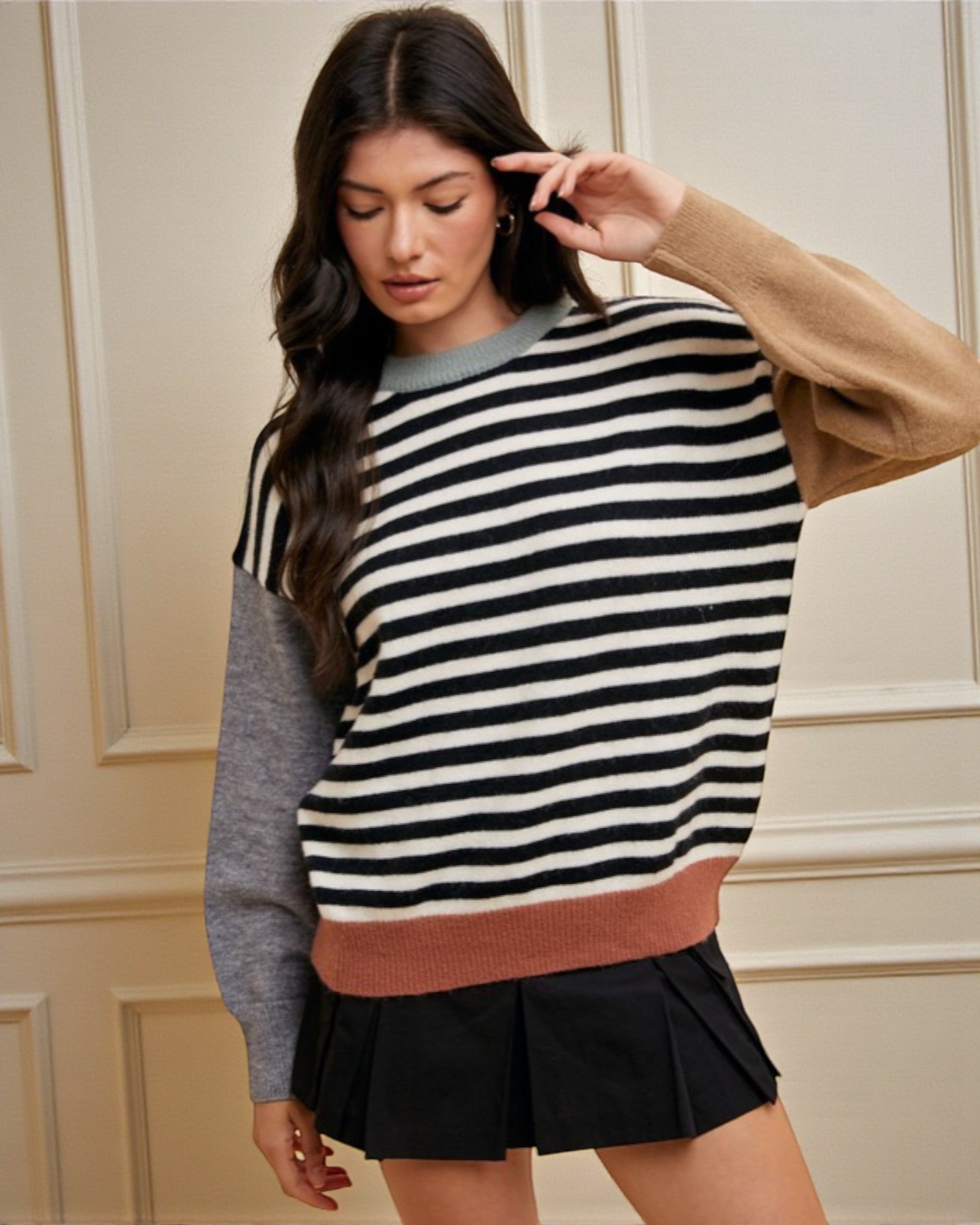 Woman wearing a striped sweater with a neutral background
