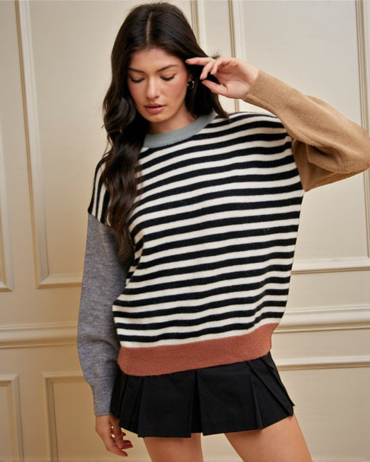Woman wearing a striped sweater with a neutral background
