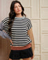 Woman wearing a black and white striped sweater with a beige background