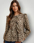 Woman wearing a leopard print blouse against a plain background