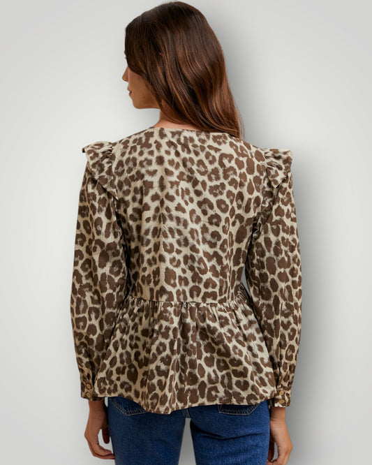 Woman wearing a leopard print blouse against a plain background