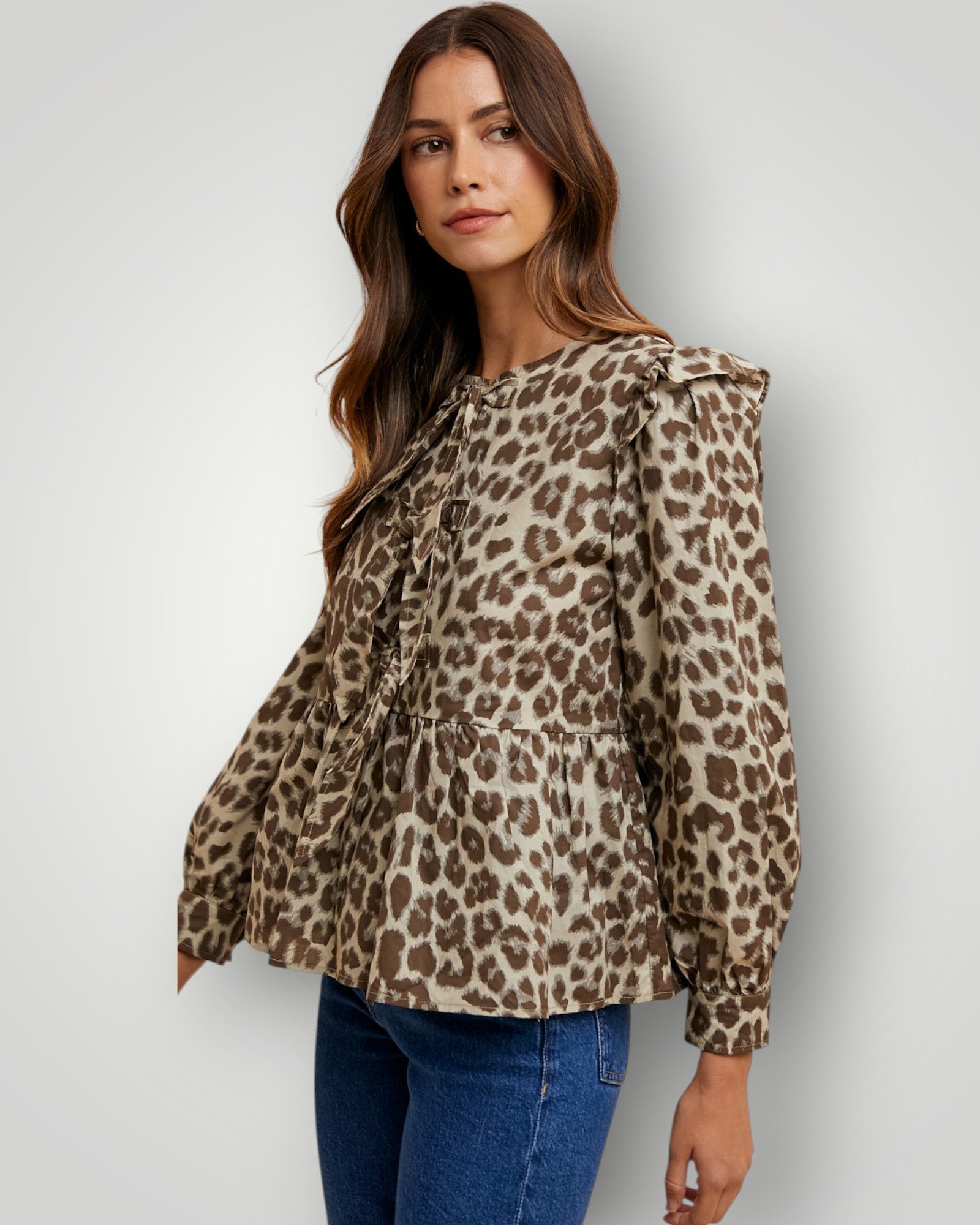 Woman wearing a leopard print blouse against a white background