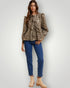 Woman wearing a leopard print top and blue jeans on a white background