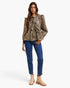 A woman modeling a leopard-print long-sleeve blouse with ruffled details, paired with blue jeans and beige ankle boots, against a plain white studio background.