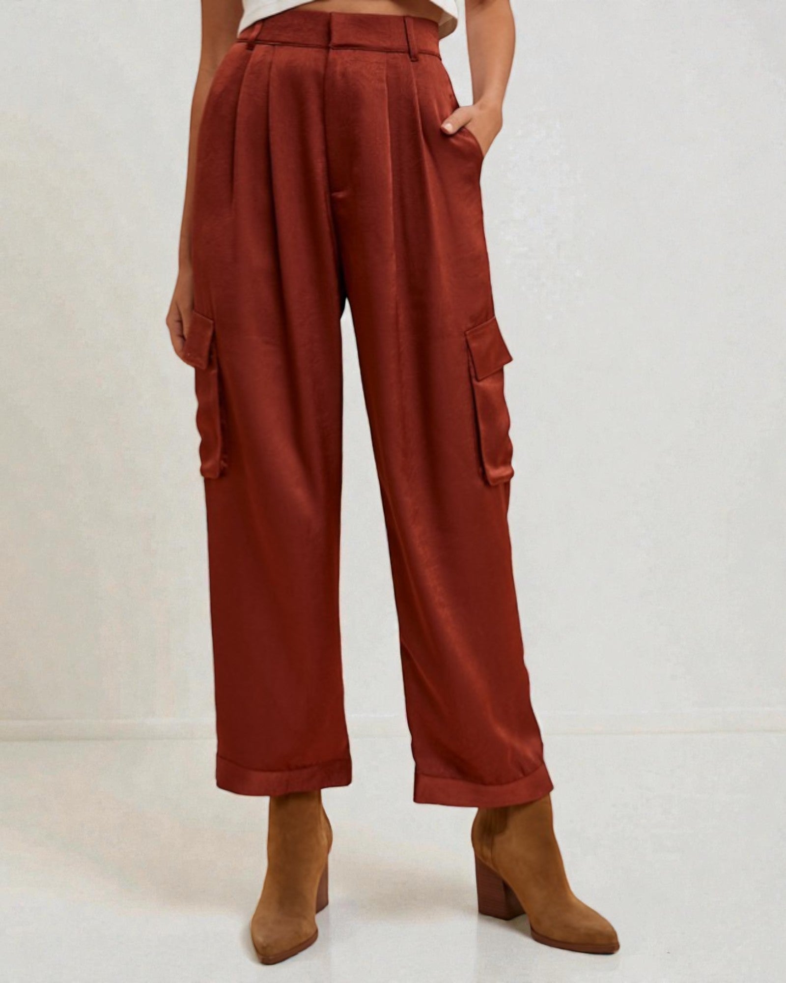 Person wearing rust-colored cargo pants with a plain background