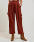 Person wearing rust-colored cargo pants with a plain background