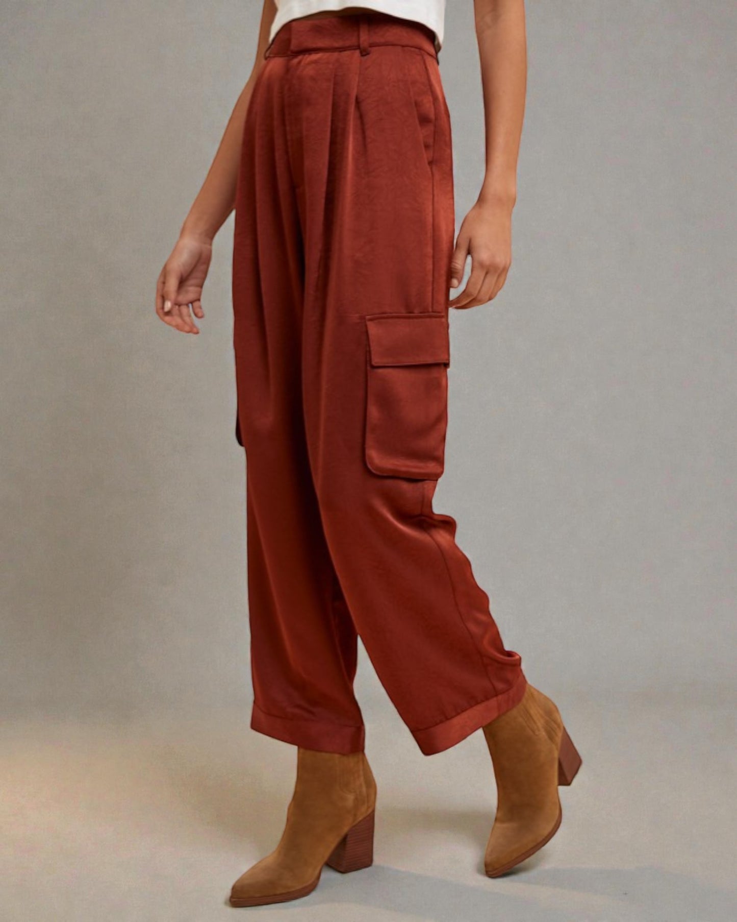 Person wearing rust-colored cargo pants with a plain background