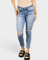 Person wearing light blue distressed jeans on a white background