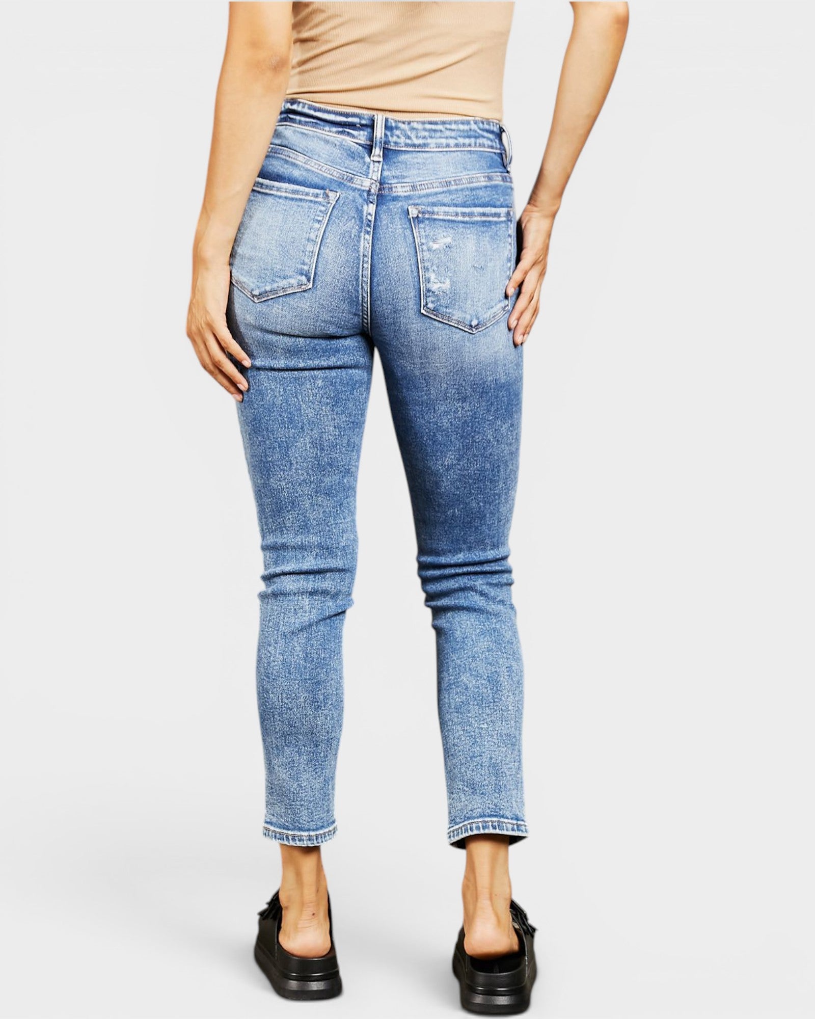 Person wearing blue jeans on a white background