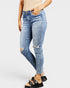 Person wearing light blue distressed jeans on a white background