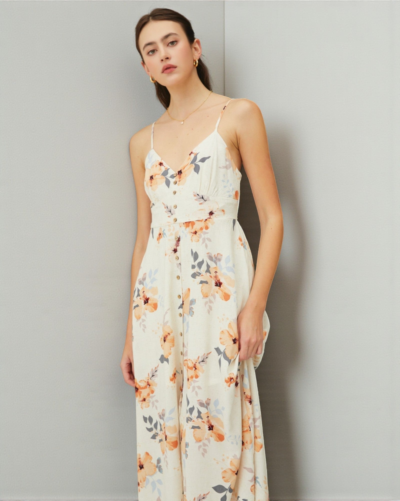 Woman wearing a floral dress against a plain background