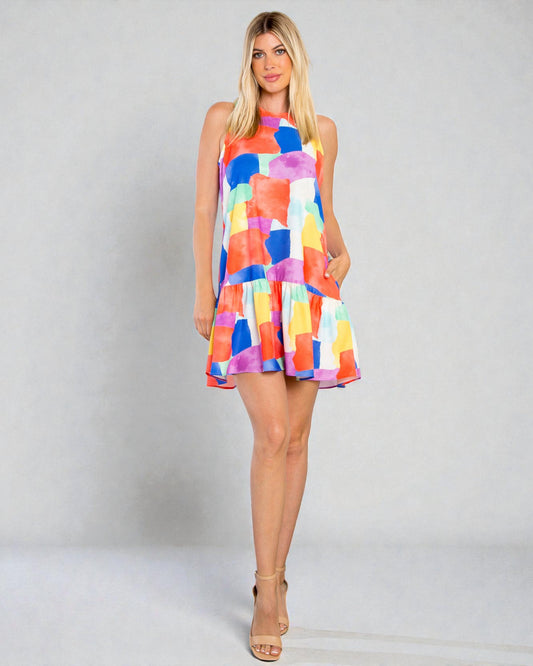 Woman wearing a colorful geometric patterned dress on a plain background