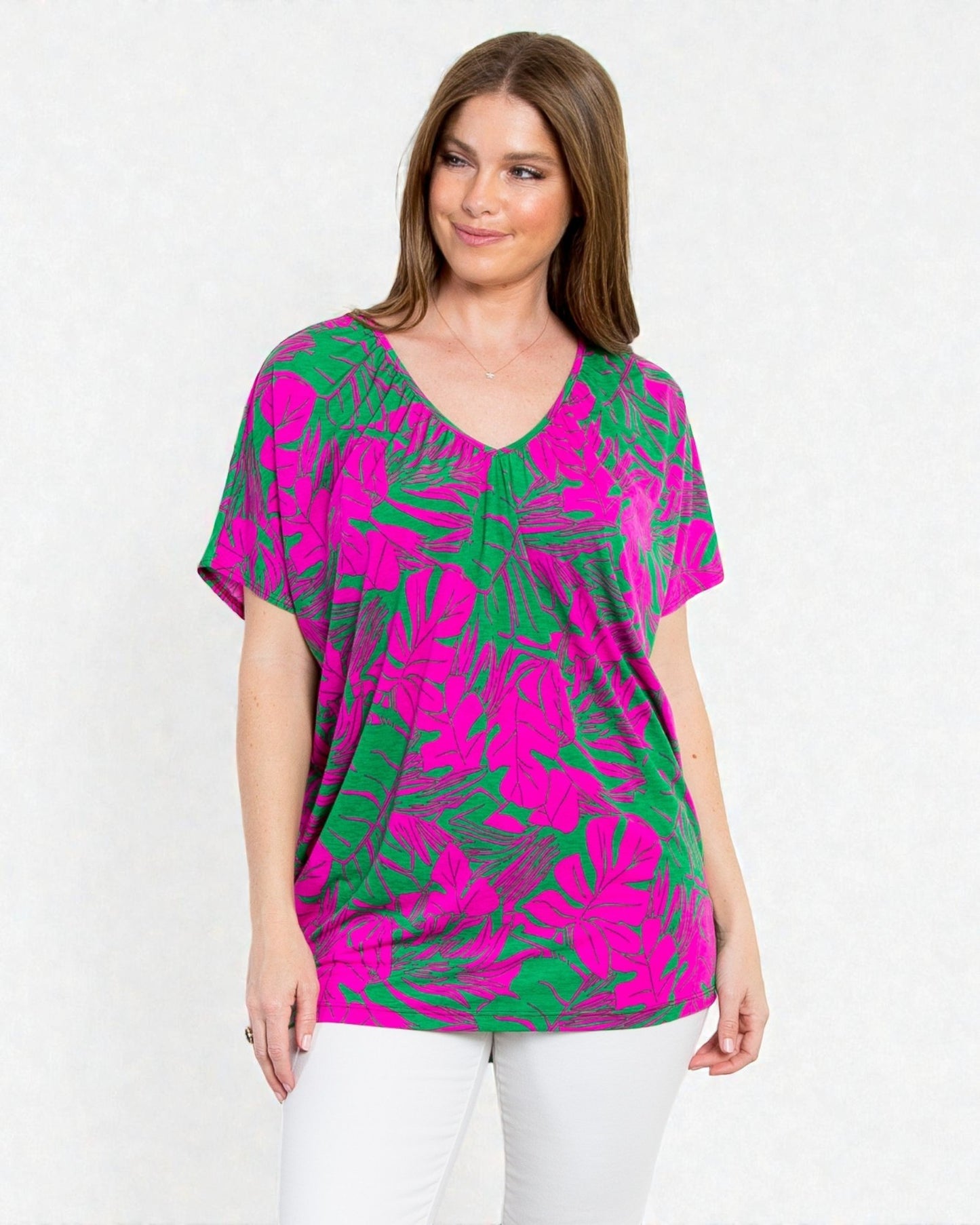 Woman wearing a pink and green patterned top on a white background