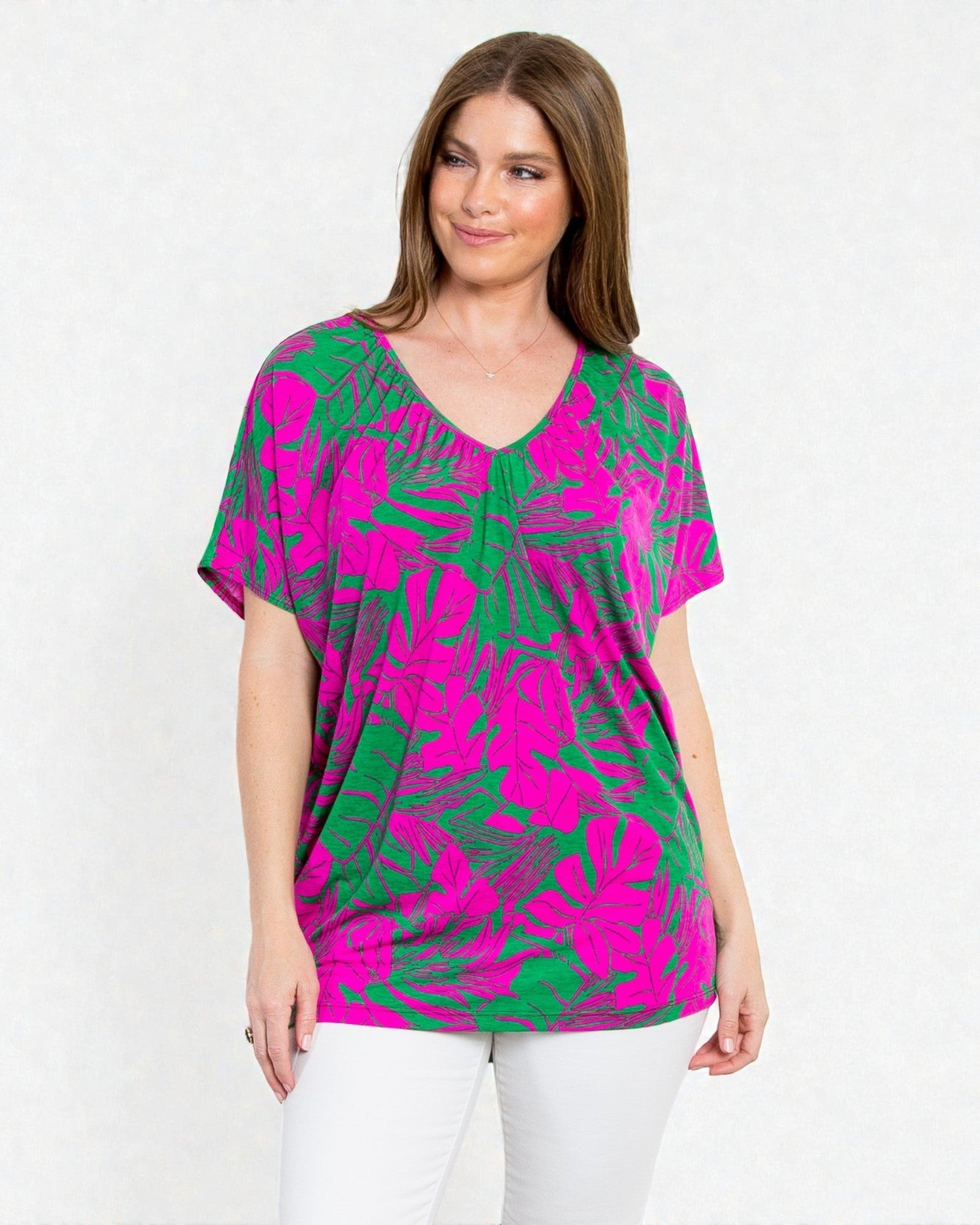 Woman wearing a pink and green patterned top on a white background