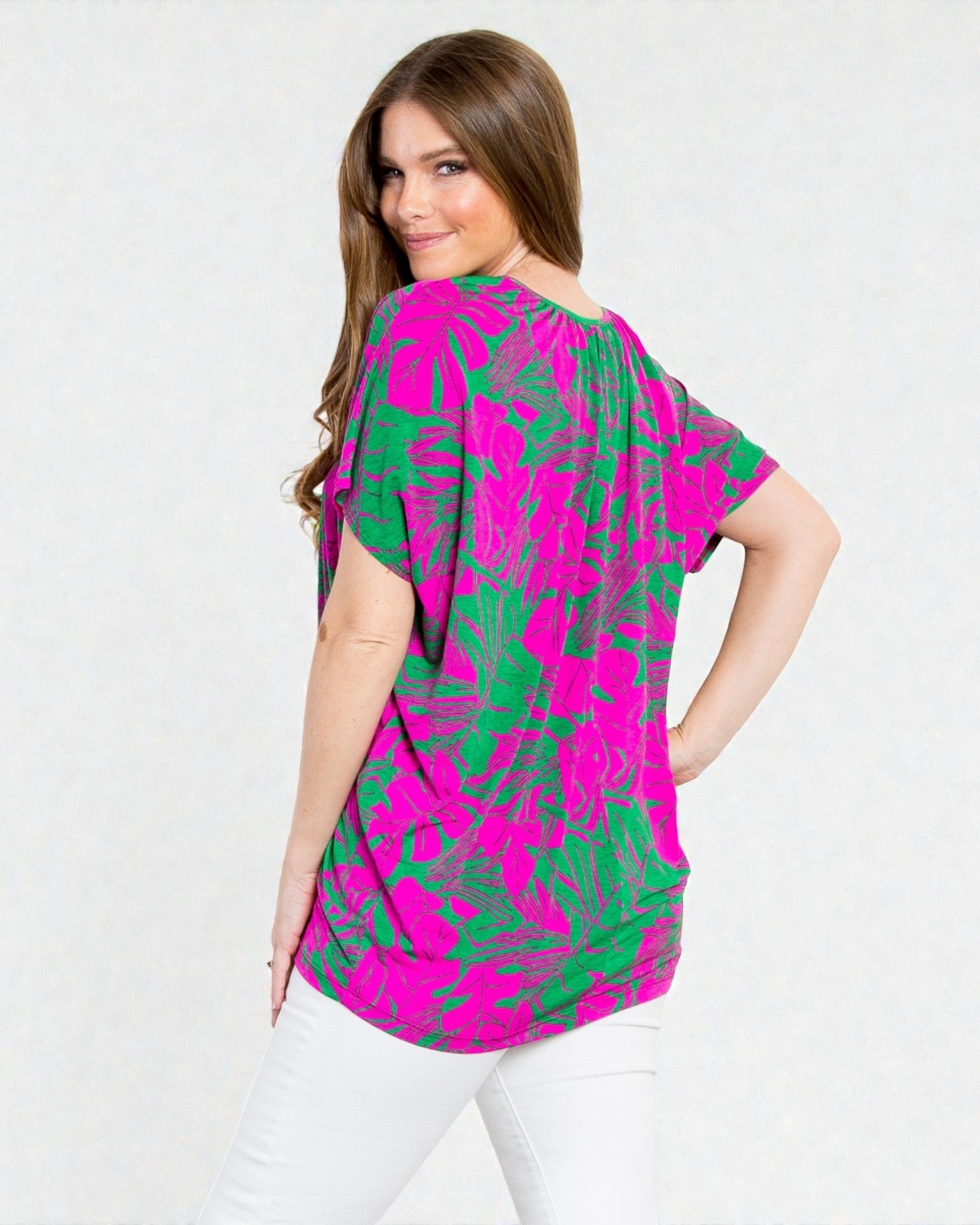 Woman wearing a pink and green patterned blouse on a white background