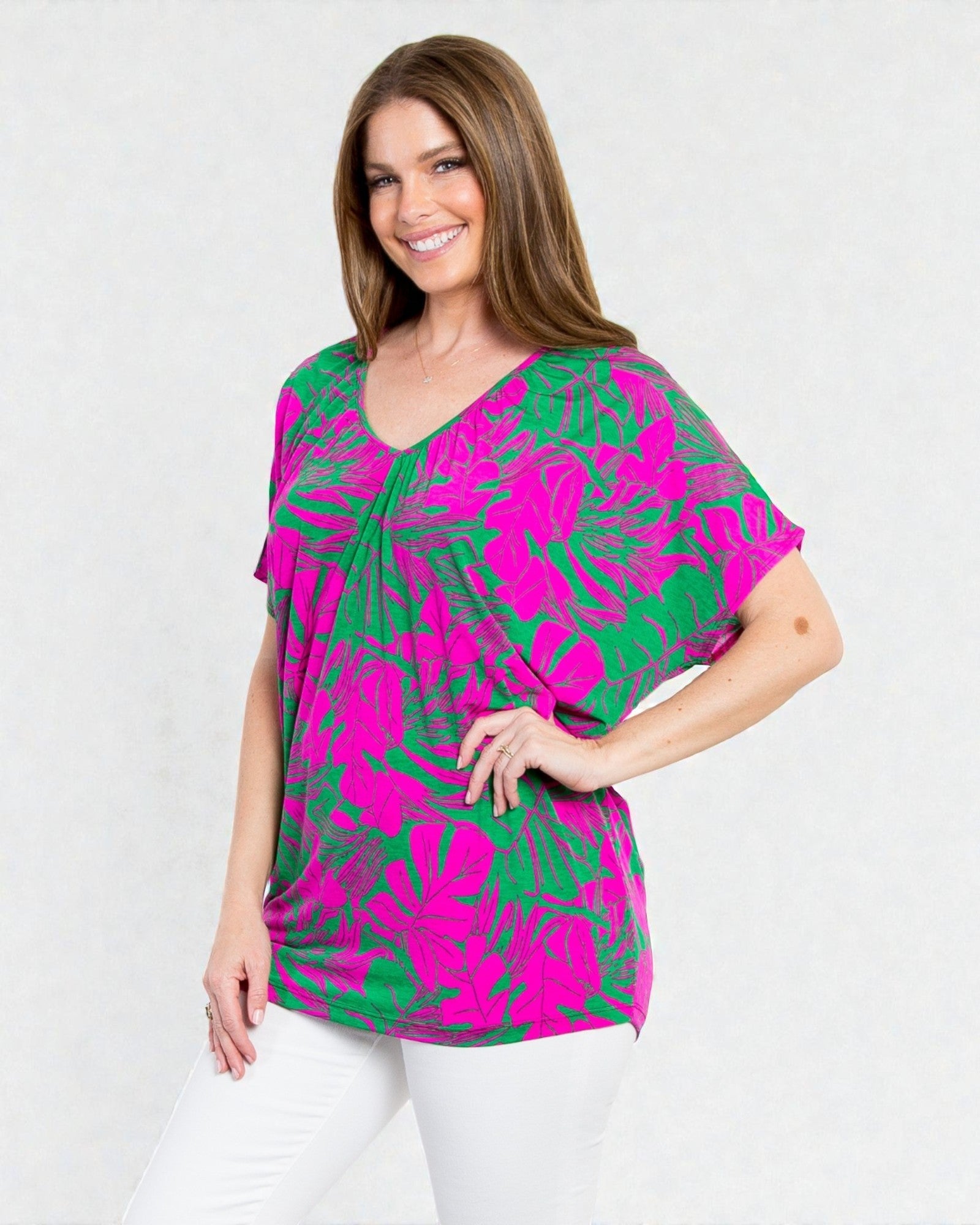 Woman wearing a pink and green patterned top on a white background