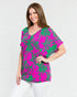 Woman wearing a pink and green patterned top on a white background