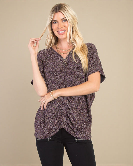 Woman wearing a brown patterned top against a beige background