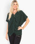 A woman modeling a dark green short-sleeve knit top with a draped front detail, paired with black pants, against a plain white background.