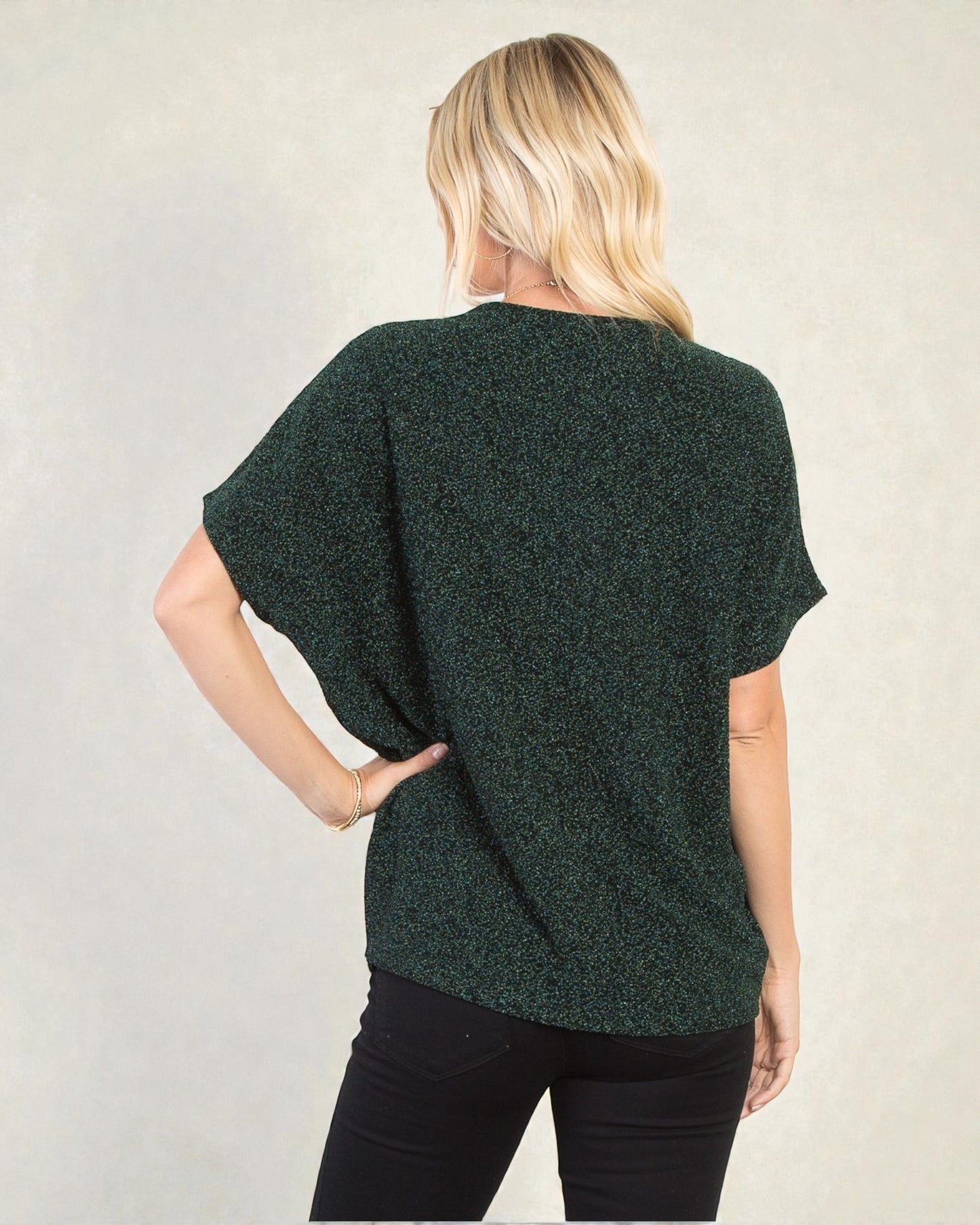 Person wearing a green textured top with a neutral background