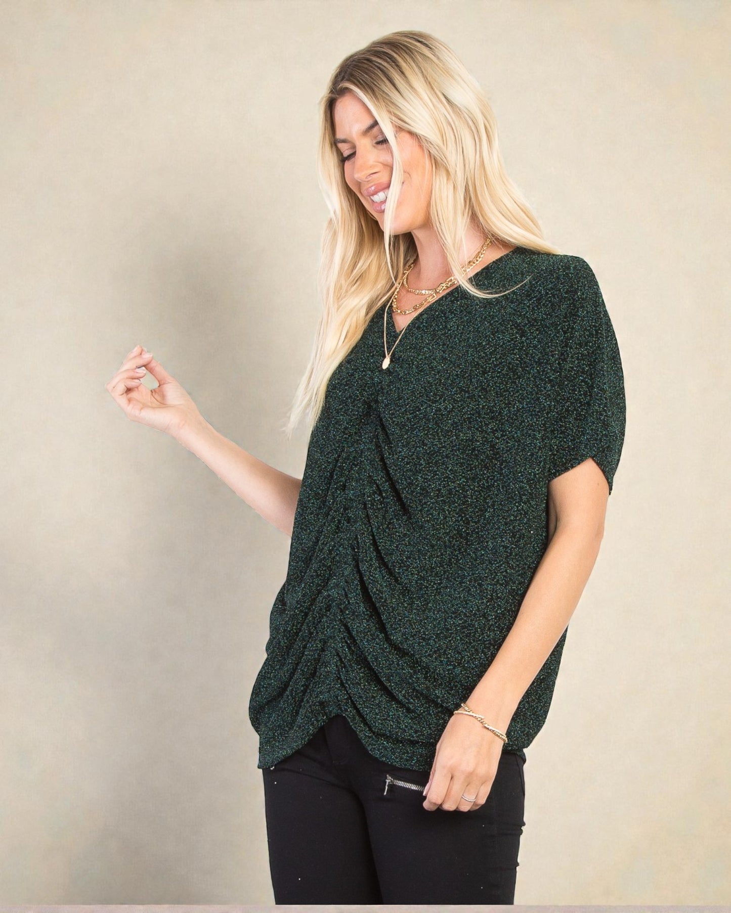 Woman wearing a green knitted top against a beige background