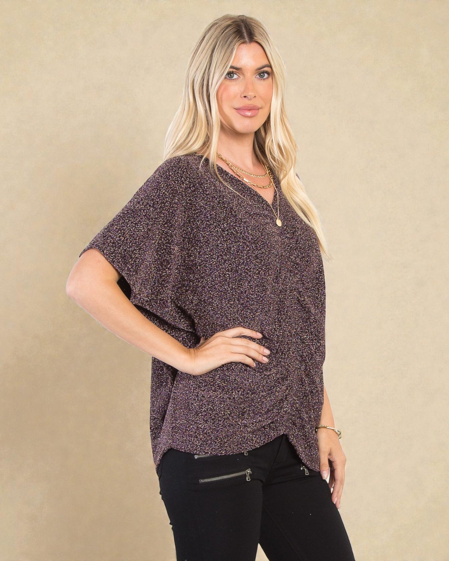 Woman wearing a brown patterned top against a beige background