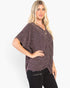 A woman modeling a short-sleeve V-neck knit top with a dark purple and black speckled pattern, paired with black pants, against a plain white background.