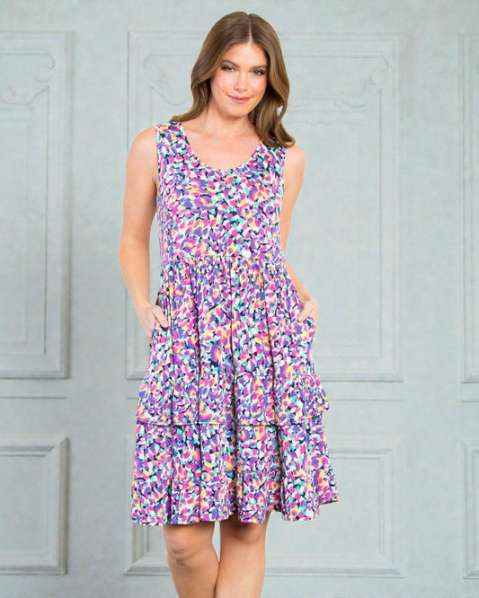 Woman wearing a colorful floral dress against a gray background