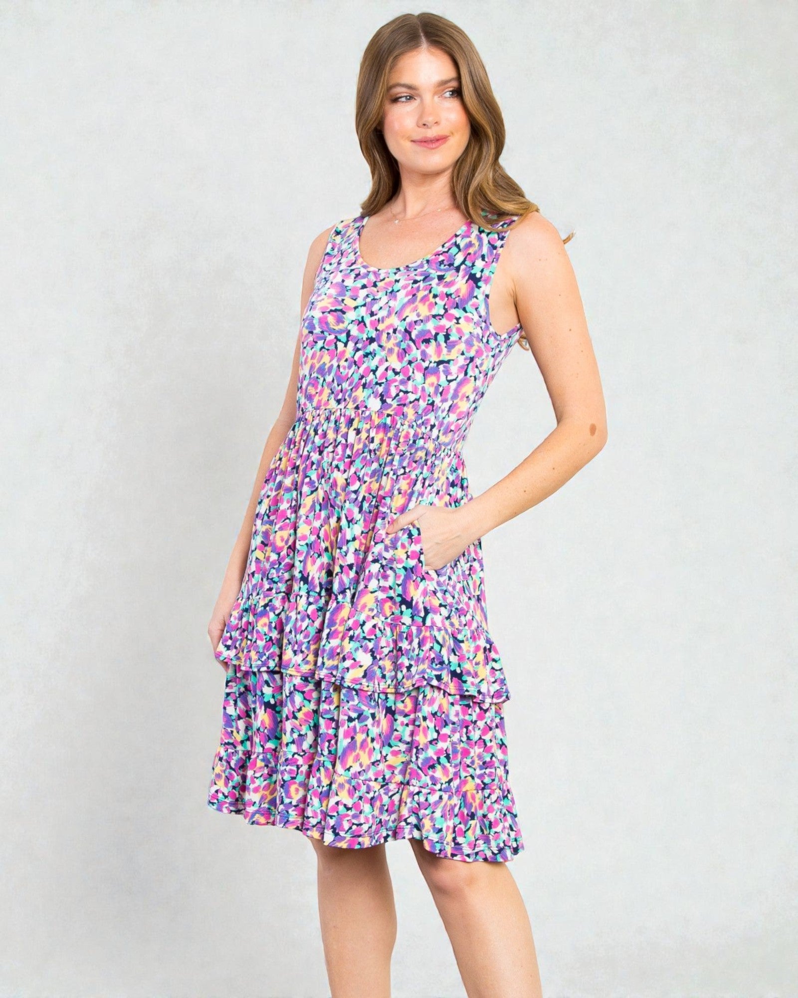 Woman wearing a colorful patterned dress on a plain background