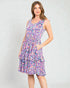 Woman wearing a colorful patterned dress on a plain background