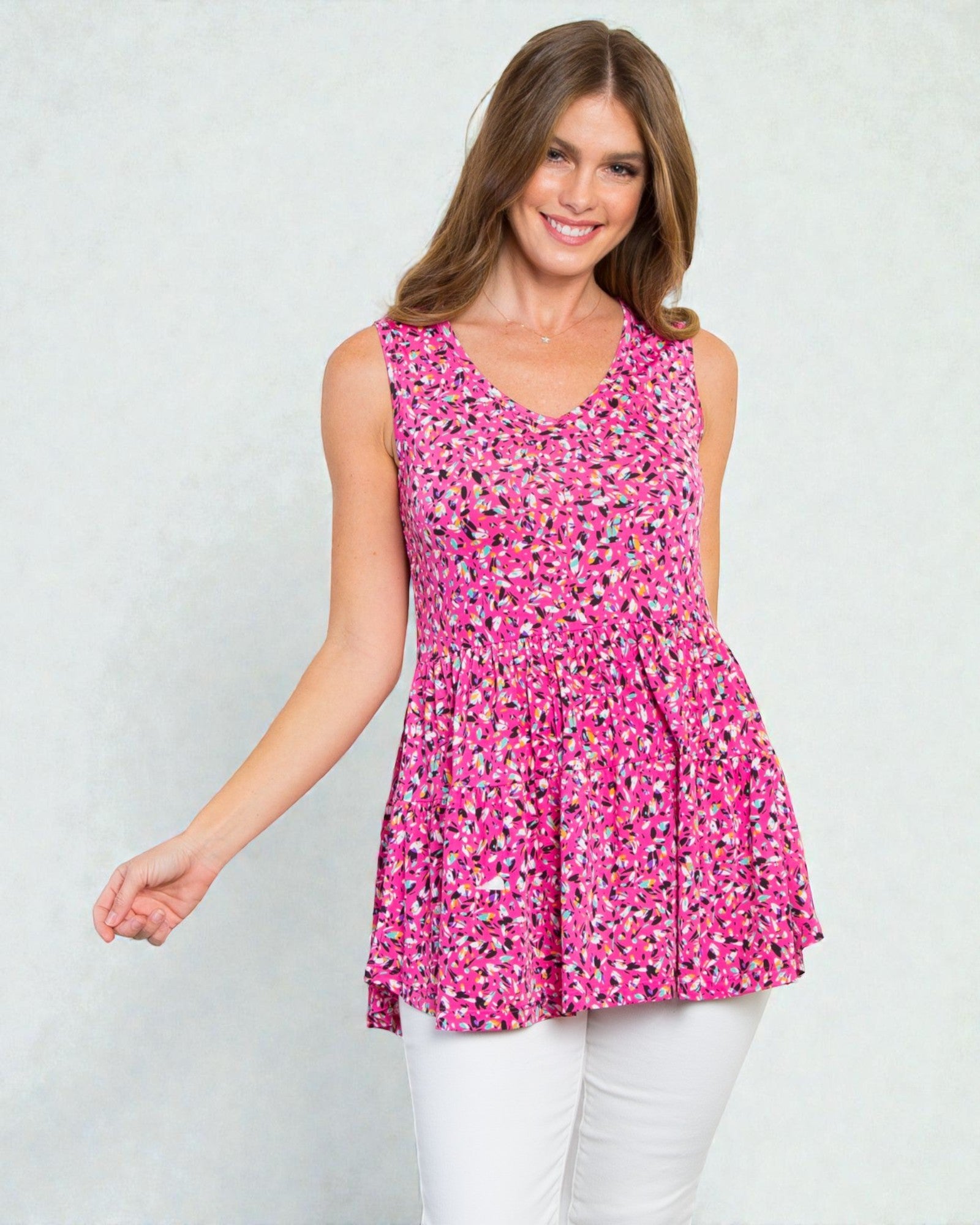 Woman wearing a pink floral sleeveless top against a white background