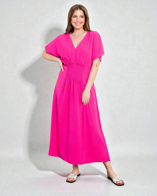 Woman wearing a bright pink dress against a plain background