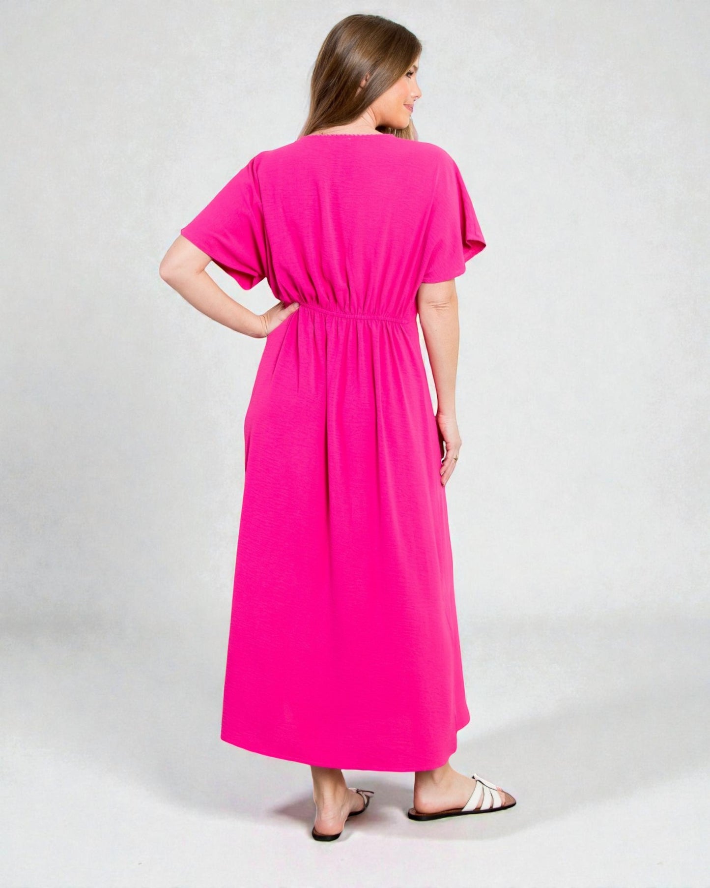 Woman wearing a bright pink dress on a white background