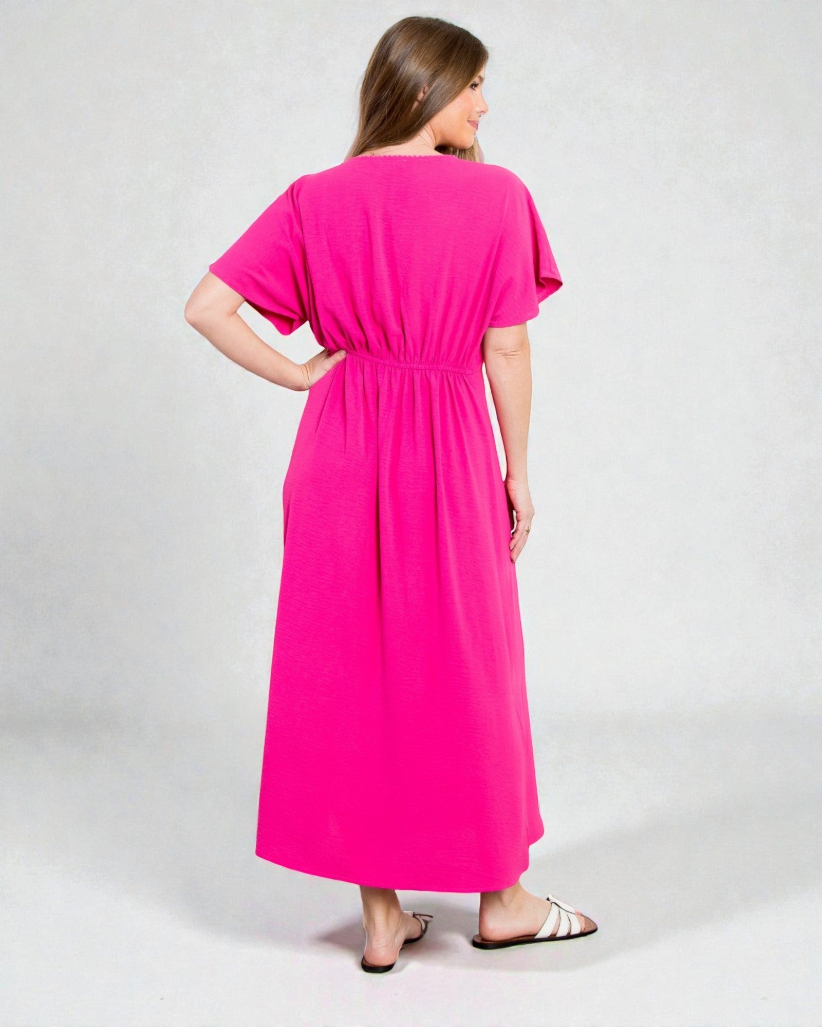 Woman wearing a bright pink dress on a white background