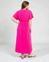 Woman wearing a bright pink dress on a white background