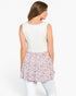 A woman shown from the back wearing a sleeveless top with a solid cream upper back and a ruffled floral skirt in pink, red, and blue, paired with white pants, against a plain white background.