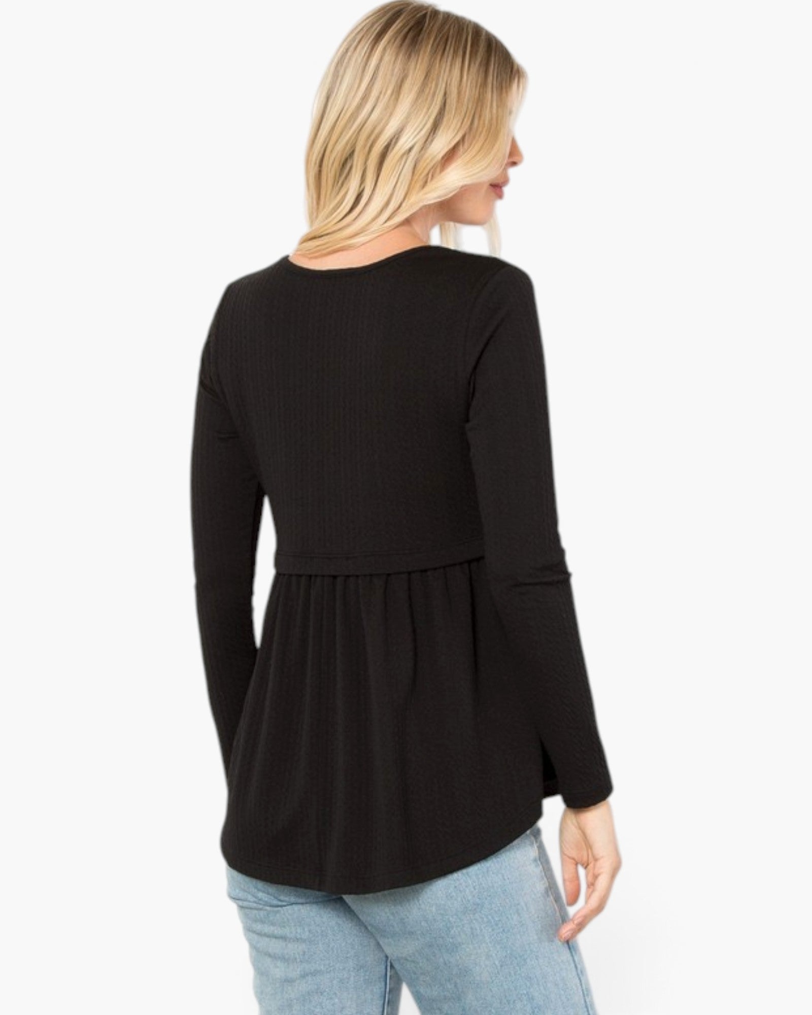A woman shown from the back wearing a black long-sleeve ribbed knit top with a peplum waist, paired with light blue jeans, against a plain white background.