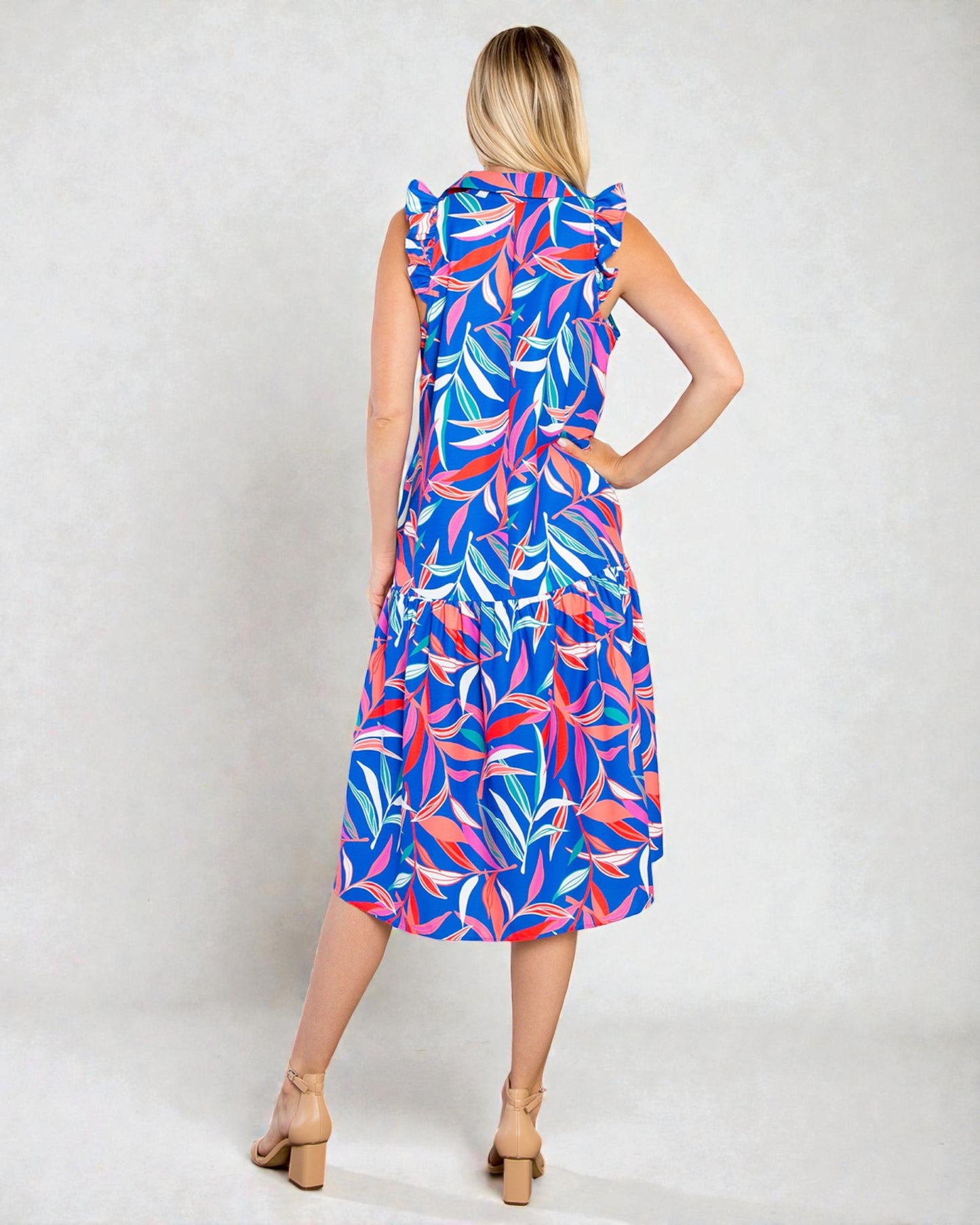 Woman wearing a colorful dress with leaf pattern on a white background