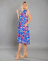 Woman wearing a colorful dress with a floral pattern on a gray background