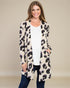 Woman wearing a leopard print cardigan over a white top and jeans on a beige background