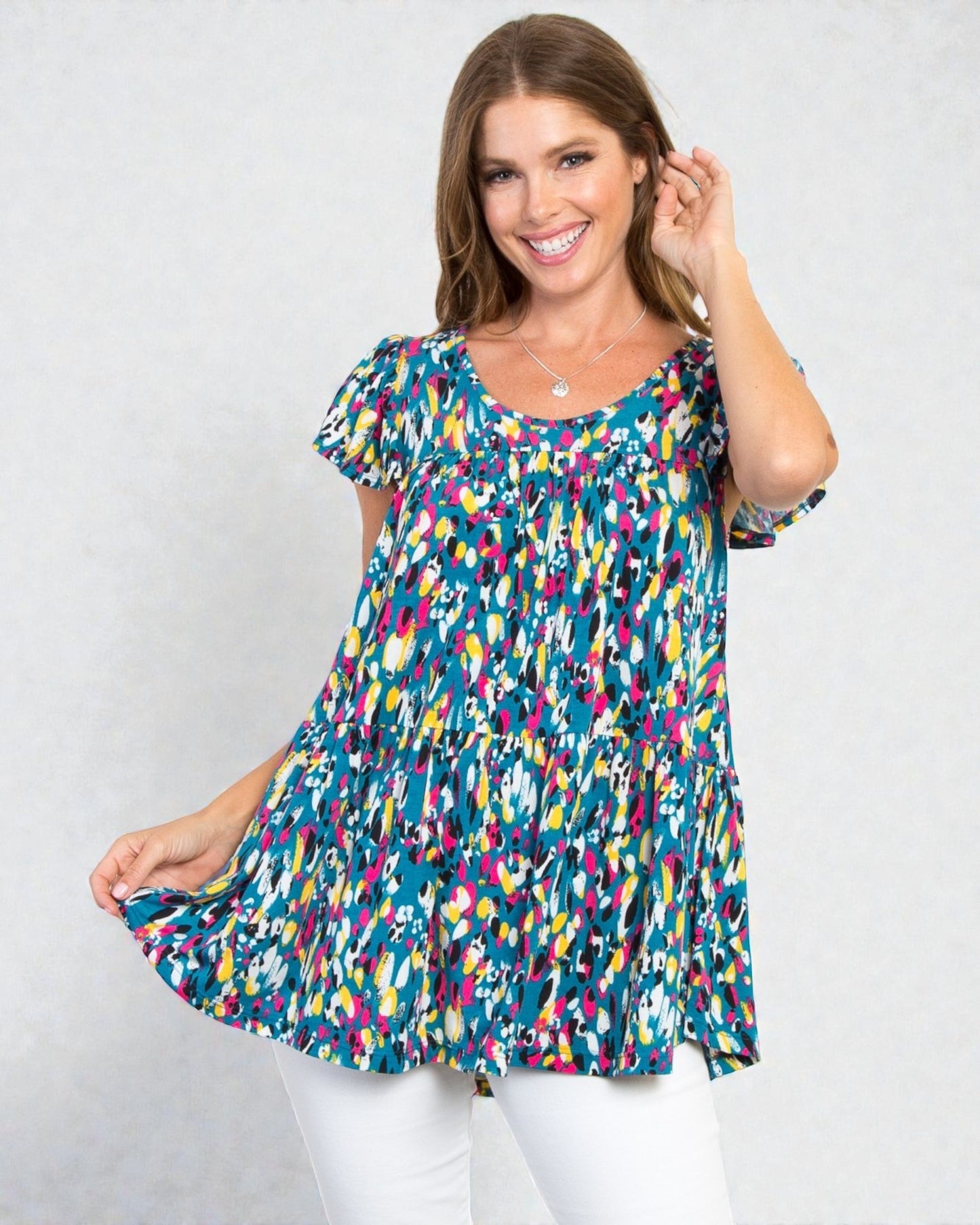 Woman wearing a colorful patterned dress against a white background